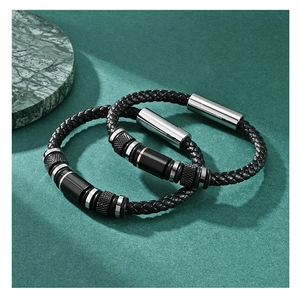 Detail of woven black leather bracelets with two-tone metal beads and magnetic clasps