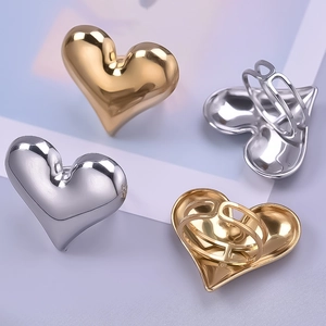 Detailed view of four irregular 3D heart rings in gold and silver stainless steel finishes