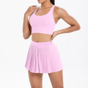 Detailed view of pink yoga set with pleated tennis skirt and breathable sports bra