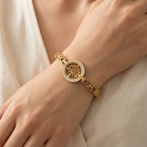 Gros plan du bracelet Arbre de Vie doré avec cristaux et chaîne à mailles gourmette