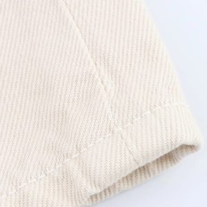 Dettaglio macro del tessuto di cotone twill beige con doppie cuciture di alta qualità