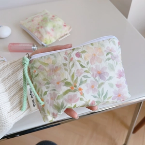 Detail of floral cotton coin pouch with a zip closure and simple wish textile label