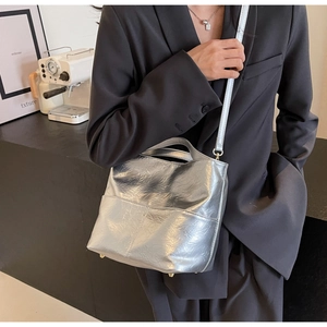 Detailed view of silver metallic tote bag with pleated texture and adjustable strap