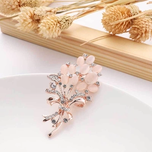 Detail of elegant rose gold bouquet brooch with pink stones and sparkling rhinestones