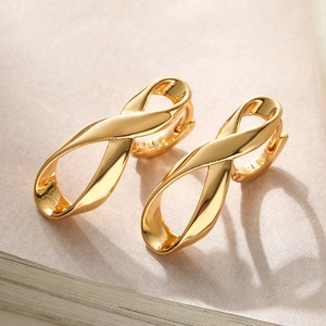 Elegant gold-plated irregular twist earrings with infinity shape on book pages