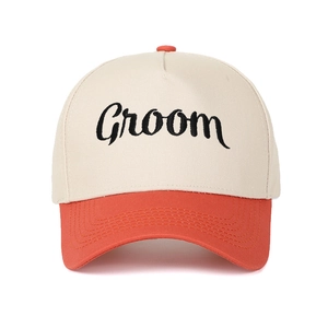 Detailansicht des gestickten Groom-Logos auf der beigen und orangefarbenen Kappe