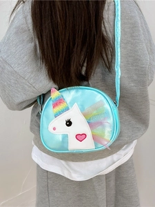 Cute bright blue unicorn crossbody bag with rainbow details worn by a young girl