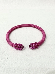 Nahaufnahme der rosa Kabeldraht-Armspange mit matten Perlen und metallischen Verzierungen