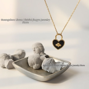 Detail of bee heart locket pendant on gold chain with retro artistic display background