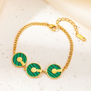 Dettaglio del bracciale in acciaio inossidabile dorato con ciondoli circolari a righe verdi