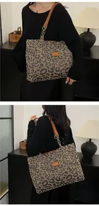 Leopard print tote bag with brown leather strap and gold chain detail in lifestyle scene