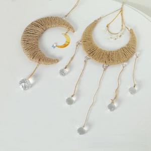 Detail of moon-shaped macrame wall hanging with crystals and gold metal ornaments