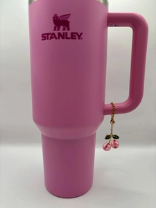 Pink stainless steel tumbler with cherry charm pendant and ergonomic side handle