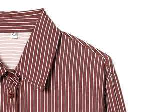 Detailed close-up of brown and white striped silk shirt collar with size tag XS