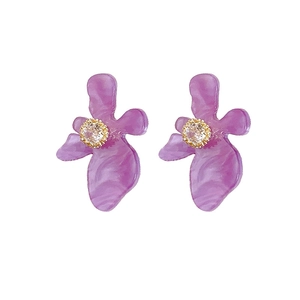 Orecchini a perno a fiore in resina viola con centri in zircone brillante su sfondo bianco