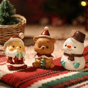 Close-up of resin Christmas miniatures with Santa, bear and snowman on knitted rug