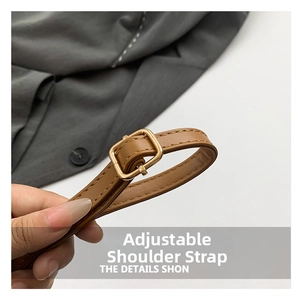 Detail of adjustable brown leather shoulder strap with gold metal buckle and stitching