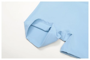 Detailed close-up of flatlock stitching on light blue high-stretch yoga shorts fabric