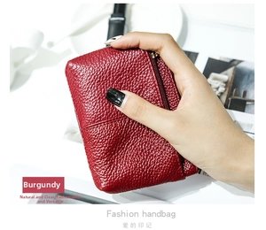 Dettaglio del mini portamonete in pelle bordeaux a grana di litchi con zip in metallo