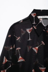 Détail d'un chemisier en mousseline avec motif martini cerise et col boutonné