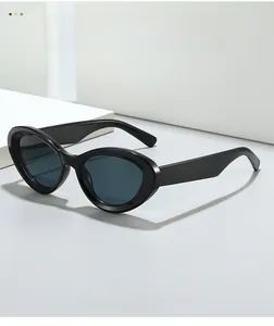 Close-up of retro black cat-eye sunglasses with thick glossy frames on a white platform