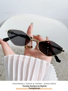 Detailed close-up of cat-eye sunglasses with gold metal frame and dark grey lenses