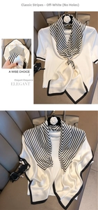 Chic black and white striped silk scarf styled on a white knit sweater with a knot