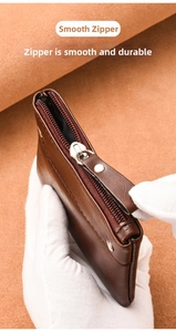 Detail view of the smooth silver zipper and premium leather texture on a brown wallet