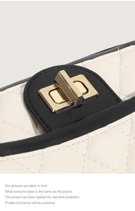 Détail d'un sac en cuir blanc matelassé avec fermoir doré et bordures noires