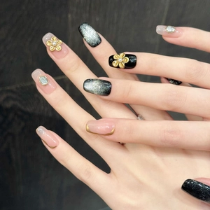 Détails de faux ongles de luxe avec fleurs dorées, perles et effet œil-de-chat brillant