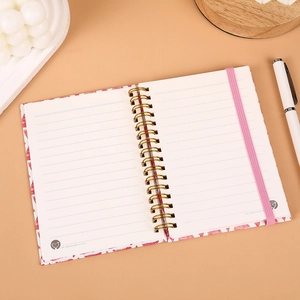 Portable A6 spiral notebook with golden wire-o binding, ruled pages and pink elastic band