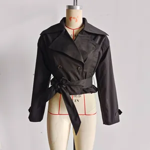 Détail d'un trench-coat court noir avec revers classique et ceinture à la taille