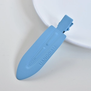 Close-up of light blue matte hair clip with UANODIAM engraving on white background