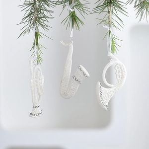 White glitter acrylic Christmas musical instruments hanging ornaments on green pine branches