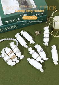 Detail of candy-shaped linen ring display sticks featuring assorted vintage jewelry pieces