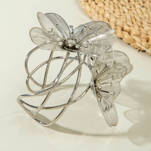 Detailed macro view of silver flower hair claw clip with rhinestones and hollow petals