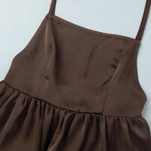 Detail of coffee brown satin top featuring adjustable thin straps and waist ruffles