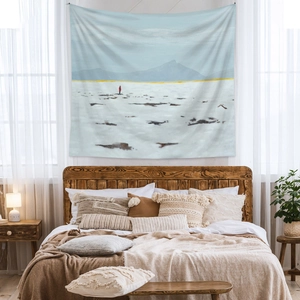 Artistic polar landscape tapestry hanging on a minimalist bedroom wall over a bed