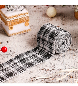 Close-up of black and white plaid Christmas ribbon with white snowflake patterns and stars