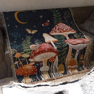 Detailed close-up of woven mushroom tapestry with fringed edges on a brown sofa
