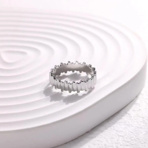 Detailed view of silver stainless steel ring with gear edge on white stone base