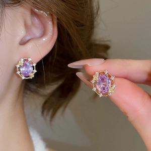 Detailed shot of 18k gold plated stud earrings featuring oval purple zircon stones
