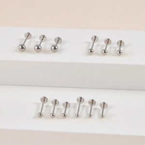 Close-up of stainless steel ball labret studs with flat back on white display stands