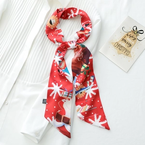 Detail of red Christmas silk scarf with Santa patterns on a white pleated shirt