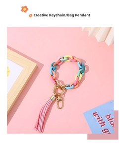 Detail of colorful matte acrylic chain keychain with pink suede tassel and gold ring
