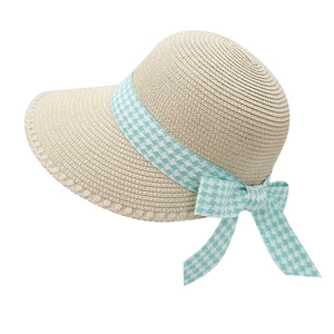 Detail of beige straw hat featuring mint green houndstooth ribbon and an elegant bow knot