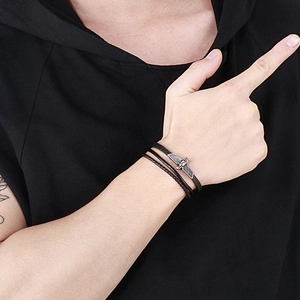 Détail d'un bracelet multicouche en cuir noir pour homme avec pendentif aigle argenté