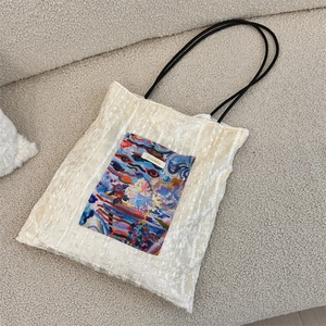 Detail of canvas tote bag showing lace texture and artistic abstract print with slim straps