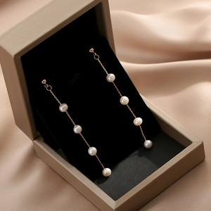 Elegant long chain gold earrings with white freshwater pearls in a premium jewelry box
