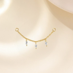 Vue détaillée d'une chaîne d'oreille dorée ornée de trois zircons étincelants de taille marquise
